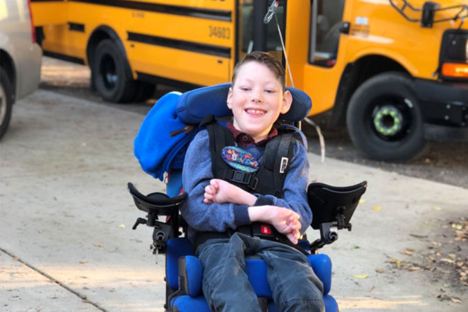 Special need boy in front of bus 